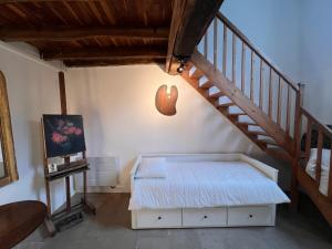 a bedroom with a bed and a staircase at La Petite Ecluse in Tanlay