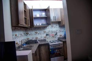 cocina con armarios de madera, fregadero y fogones en Lumière de Ville, en Kigali 11 fotos más