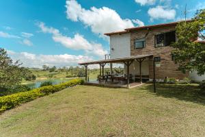 a house with a deck next to a river at La Villa, Espectaculares vistas al lago Peñol-Guatape in Guatapé