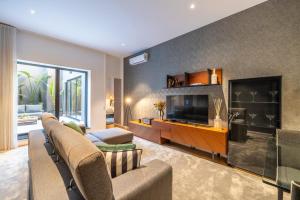 een woonkamer met een bank en een televisie bij Chãos Design By Minho's Guest in Braga