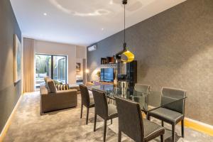 een eetkamer en een woonkamer met een glazen tafel en stoelen bij Chãos Design By Minho's Guest in Braga