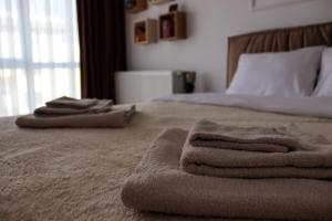 a bedroom with a bed with towels on it at ApArte Suite in Râşnov