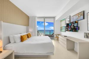 好莱坞Amazing Oceanfront Views From 24th floor!的一间卧室，配有一张床、一张书桌和一扇窗户