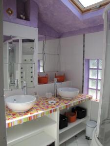 a bathroom with two sinks and a mirror at Gite De Charme Auvergne Cab'âne in Brousse