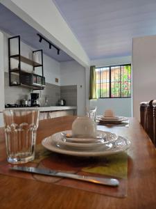a table with plates and a glass on top of it at Casa di flor in Alto Paraíso de Goiás +7 photos