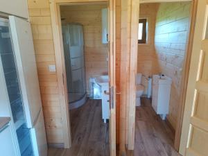 a bathroom with two toilets and a shower and a sink at Domki z klimatyzacją in Prażmowo