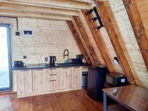 a kitchen with wooden cabinets and a brick wall at AA Frame Retreat Fundata in Fundata