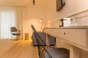a living room with a table and chairs and a tv at De Sjeiven Dorpel in Maaseik