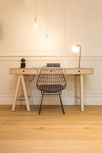 a desk with a chair and a lamp in a room at De Sjeiven Dorpel in Maaseik