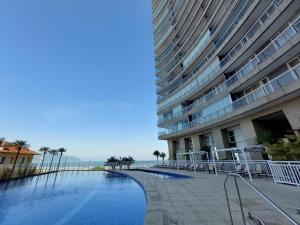 a large building with a swimming pool next to a building at Book Santos – Unlimited 1808 c/ Sacada Panorâmica in Santos