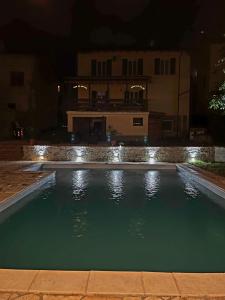 a swimming pool in front of a house at night at La casa tra le vigne in SantʼAndrea