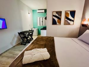 a bedroom with a bed with a towel on it at Flats da Garça - Praia de Garça Torta em Maceió in Maceió