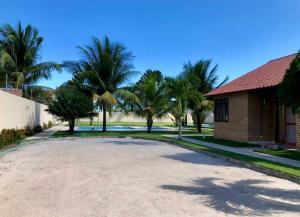 a driveway with palm trees and a house at Casa Praia do Frances in Marechal Deodoro