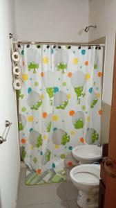 y baño con cortina de ducha y aseo. en Depto la Tere 2, en Córdoba