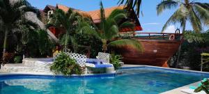 una casa con piscina con sedie e barca di El Arca de Pachue a Punta Chame