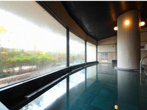 a swimming pool in a building with a large window at The Paradise Garden Sasebo - Vacation STAY 90006v in Sasebo