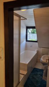 a bathroom with a bath tub and a toilet at Elfi's Appartments in Leichlingen +44 photos