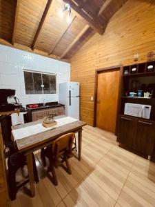 a kitchen with a table and a refrigerator at Cabanas dos Sonhos 2- Barra de Ibiraquera in Imbituba +18 photos
