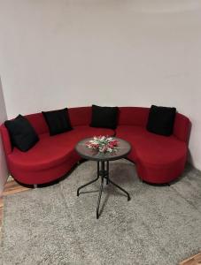 a red couch sitting in a living room with a table at Villa Ramiela in Arad +7 photos