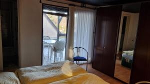 a bedroom with a bed and a balcony with a table and chairs at Elfi's Appartments in Leichlingen