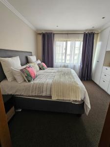 a bedroom with a bed with pillows and a window at Bedfortgardens in Johannesburg