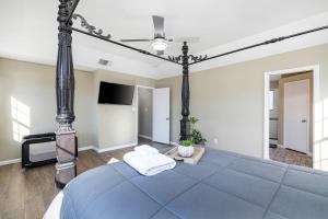 a bedroom with a blue bed and a flat screen tv at Spacious 4BR Home with Pool BBQ & Games in Grand Prairie +25 photos