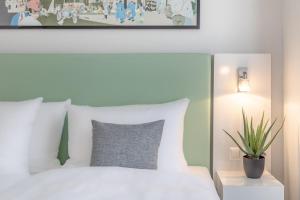 a bedroom with a white bed and a plant at Garner Hotel Berlin - Checkpoint Charlie by IHG in Berlin +55 photos