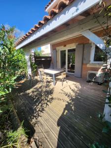 卡勒维松Maison de vacance toute équipée的房屋内带桌椅的木制甲板