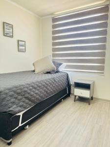 a bedroom with a bed and a large window at Departamento in Antofagasta +15 photos