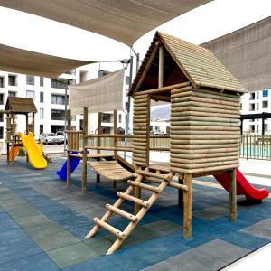 a playground with a wooden play structure and a slide at Departamento in Antofagasta