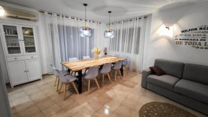 a dining room with a table and chairs and a couch at El Mirador dels Ports in Paúls