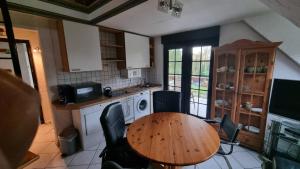 a kitchen with a wooden table and chairs in it at Elfi's Appartments in Leichlingen
