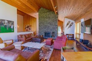 a living room with couches and a stone fireplace at Stratton Mountain Ski House Hot Tub Sauna Shuttle in Stratton Mountain
