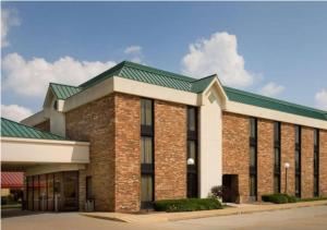 a large brick building with a green roof at Wingate by Wyndham St Louis-Fenton Route 66 in Fenton