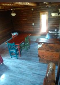 a dining room with a table and chairs in a cabin at Alojamiento en san clemente Pampa y Rio cabaña Lihuel in Santa María