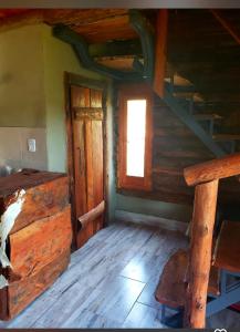 an attic room with a staircase and a window at Alojamiento en san clemente Pampa y Rio cabaña Lihuel in Santa María