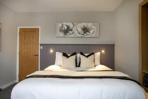 a bedroom with a large bed with white sheets and pillows at Entire Luxurious 2 Bedroom Flat in Leicester +51 photos