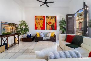 a living room with two couches and a tv at Spanish Penthouse Historic Mansion Private Patio in San Juan