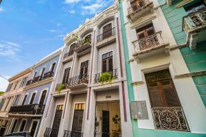 a tall white building with balconies on a street at Spanish Penthouse Historic Mansion Private Patio in San Juan