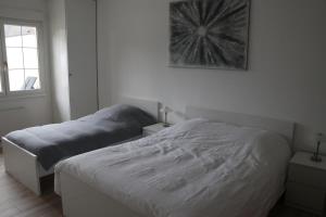 a bedroom with two beds and a picture on the wall at L'Orée du Bois in Longeville-lès-Saint-Avold