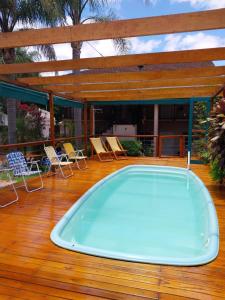 a hot tub on a deck with chairs and a pergola at Le Soleil Apart Hotel in Colón
