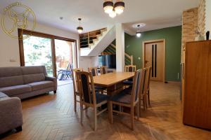 a dining room and living room with a table and chairs at Mazurska Sarenka in Wiartel