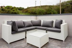a white couch sitting on top of a patio at Apartamentos Borizu Playa in Barro de Llanes