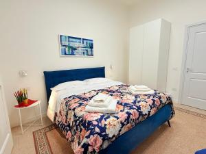 a bedroom with a blue bed with towels on it at Ideal Suite 41 Pagani in Pagani