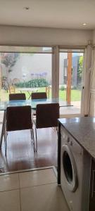 マル・デル・プラタにあるCasa Lapridaのキッチン(テーブル、椅子、洗濯機付)