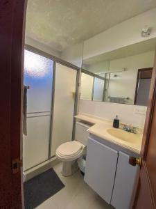 un bagno con un water, un lavandino e uno specchio di Apartamento Sur De Cali Santa Anita Excelente Ubicación a Cali Altre 12 foto
