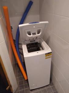 a trash can in a corner with a blue hose at Kaksio Kivitipun lähellä in Lappajärvi