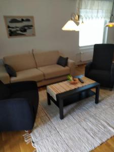 a living room with a couch and a coffee table at Kaksio Kivitipun lähellä in Lappajärvi +1 photo