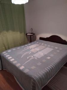 a bedroom with a bed with a purple comforter at Kaksio Kivitipun lähellä in Lappajärvi