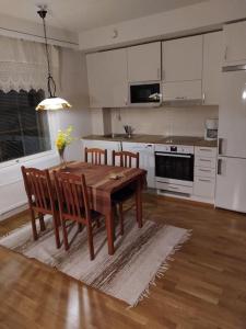 a kitchen with a wooden table and chairs in it at Kaksio Kivitipun lähellä in Lappajärvi